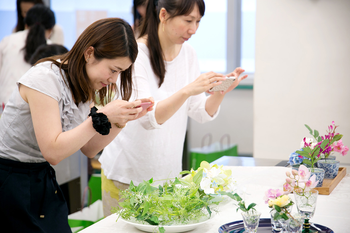 製作したテーブルフラワー作品を写真に撮る生徒さん